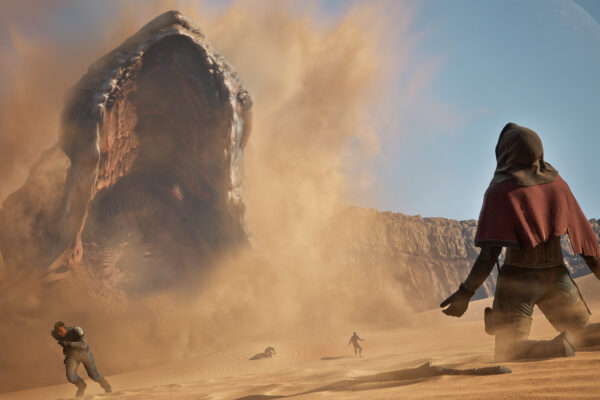 Un personaje observa un gigantesco gusano de arena en Dune Awakening