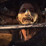 Una guerrera con máscara dorada sostiene una katana en Ghost of Yōtei