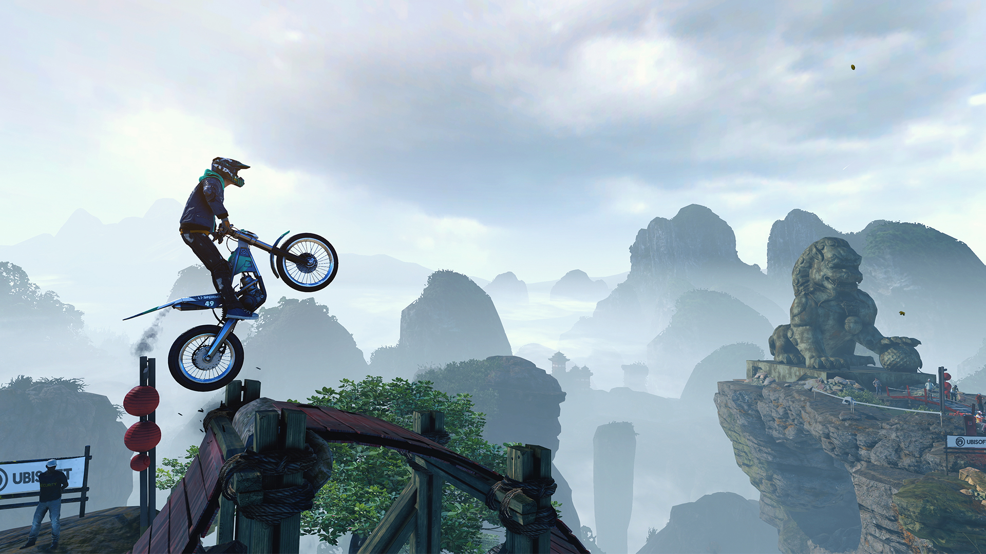 Un motorista de Trials Rising salta sobre unas rocas con montañas al fondo